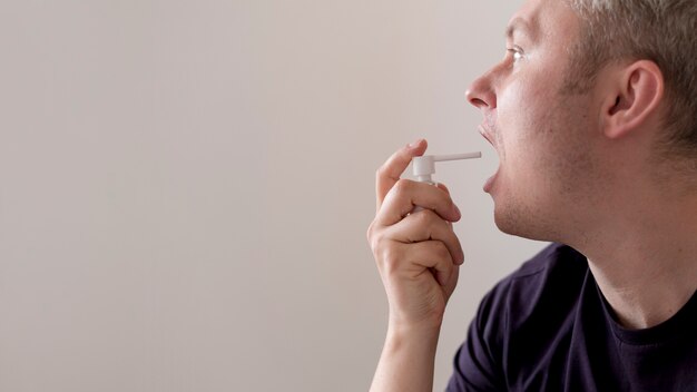 Hombre usando tratamiento para dolor de garganta copia espacio