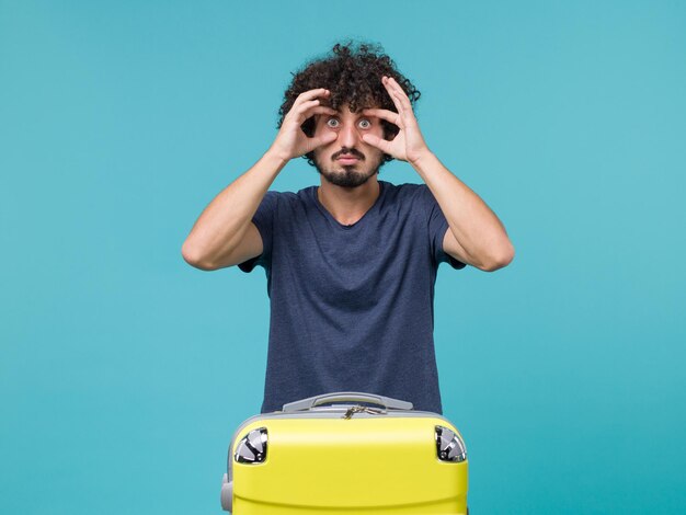 Hombre de vacaciones en camiseta azul abriendo ampliamente los ojos en azul