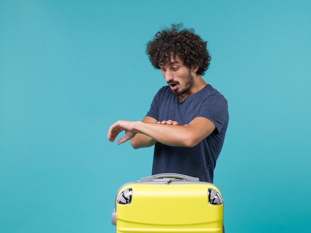 hombre en vacaciones comprobando el tiempo en azul