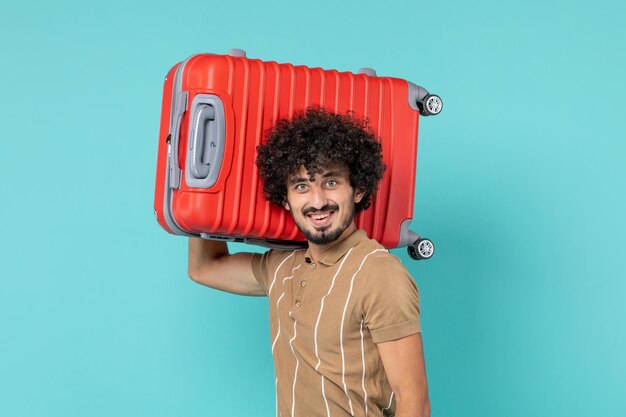Hombre de vacaciones con maleta grande sonriendo en azul