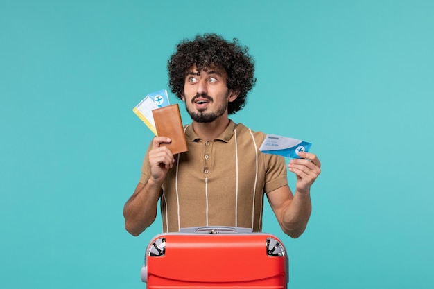 hombre de vacaciones sosteniendo boletos en azul