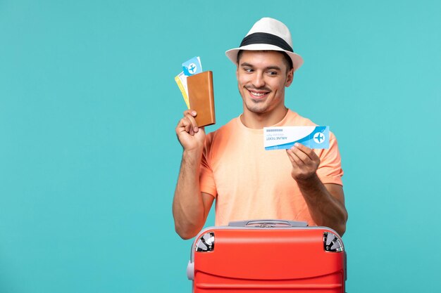 Hombre de vacaciones sosteniendo su boleto en azul