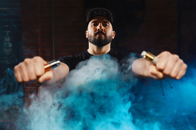 Foto gratuita hombre vaping un cigarrillo electrónico