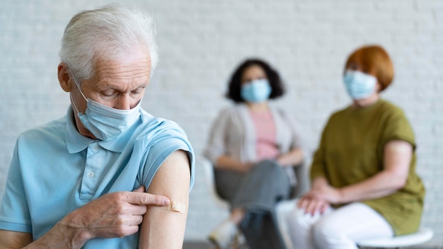 Hombre con vendaje en el brazo después de la vacunación