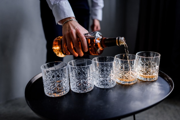 Foto gratuita el hombre está vertiendo la fuerte bebida alcohólica en el vaso