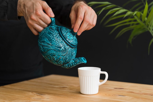 Foto gratuita hombre vertiendo té en la taza