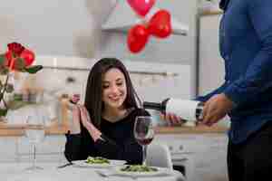 Foto gratuita hombre vertiendo vino en un vaso para su novia