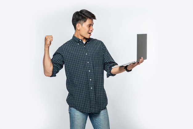 El hombre vestía una camisa blanca y pantalones oscuros, sostenía una computadora portátil y fingía estar alegre.