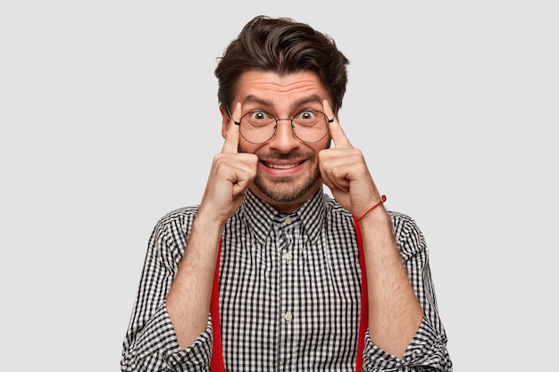 Hombre vestido con camisa a cuadros y tirantes rojos