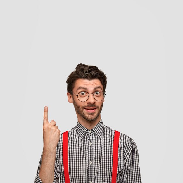 Hombre vestido con camisa a cuadros y tirantes rojos