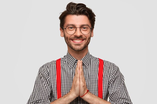 Hombre vestido con camisa a cuadros y tirantes rojos