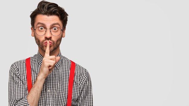 Hombre vestido con camisa a cuadros y tirantes rojos