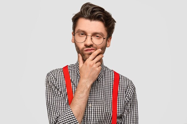 Hombre vestido con camisa a cuadros y tirantes rojos