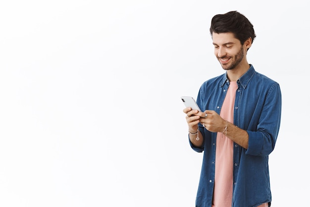 Foto gratuita hombre vestido con camisa vaquera y con smartphone en blanco