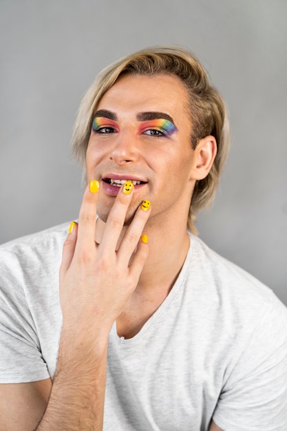 Hombre vestido con cosméticos de maquillaje y vista frontal de esmalte de uñas