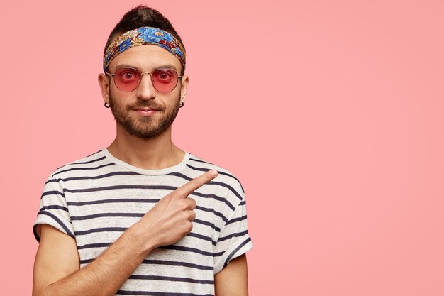 Hombre vestido con gafas de sol rosas y pañuelo colorido