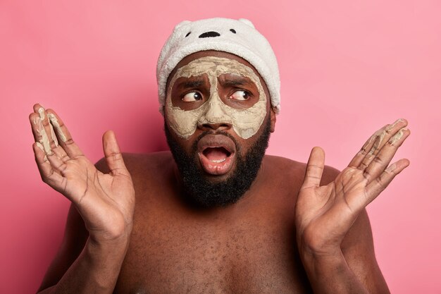 Hombre vestido con máscara cosmética en la cara para el cuidado de la piel dermatología