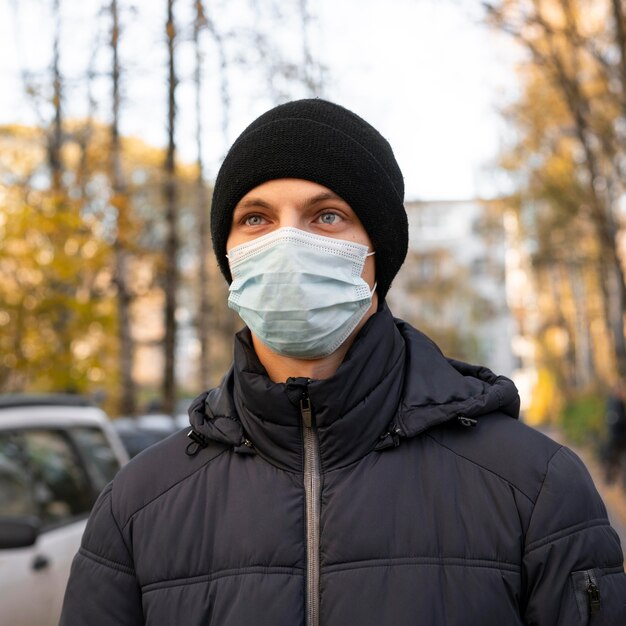 Hombre vestido con máscara médica en la ciudad