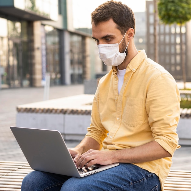 Foto gratuita hombre vestido con mascarilla al aire libre