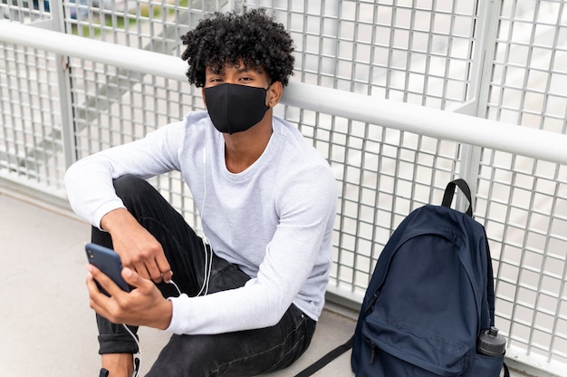 Foto gratuita hombre vestido con mascarilla de tiro medio