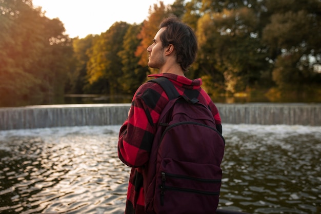 Hombre vestido con mochila de tiro medio