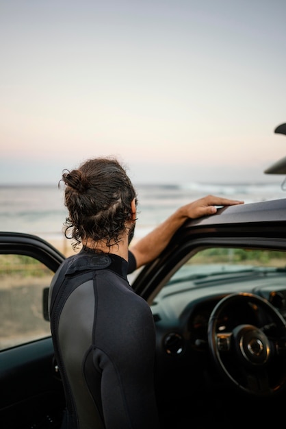 Foto gratuita hombre vestido con ropa de surfista desde atrás shot