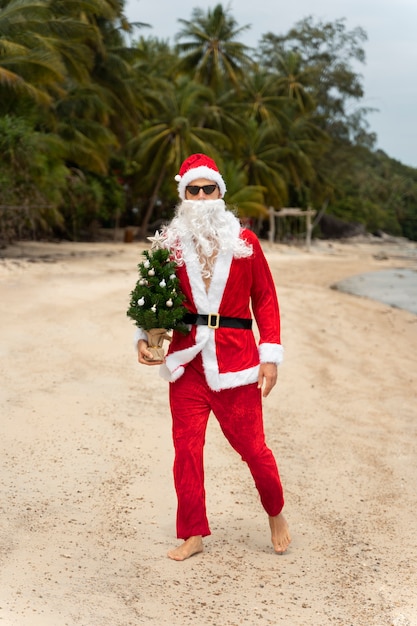 Hombre vestido de santa claus celebrando la navidad en julio