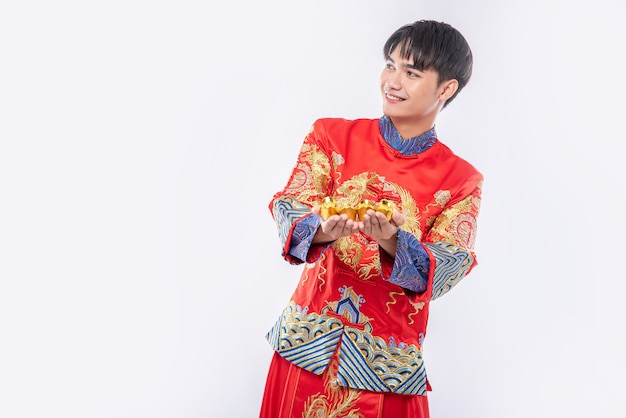 Hombre vestido con traje Cheongsam regalar oro a su pariente por suerte en año nuevo chino