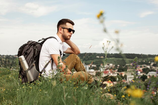 Hombre viajando solo descansando en campo verde