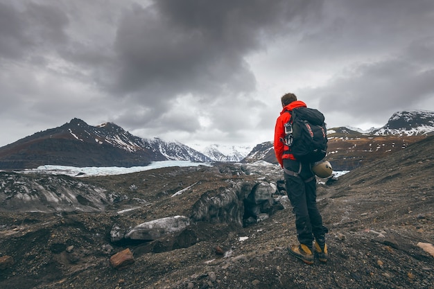 Hombre de viaje de aventura de senderismo viendo el glaciar en Islandia.