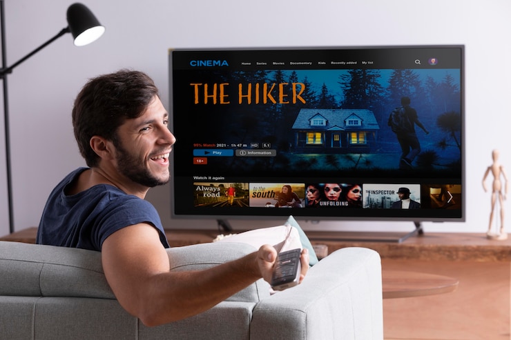 Foto gratuito hombre viendo su película favorita en la televisión