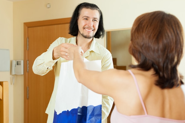 Foto gratuita el hombre vino a la mujer con un regalo en casa