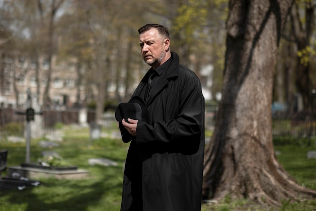 Hombre visitando lápidas en el cementerio