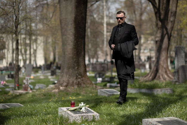 Hombre visitando lápidas en el cementerio