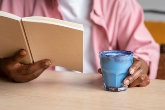 Foto gratuita el hombre de la vista delantera disfrutando de un matcha azul