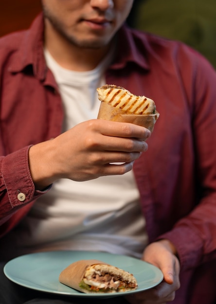 Foto gratuita el hombre de la vista delantera con un sándwich envuelto en papel