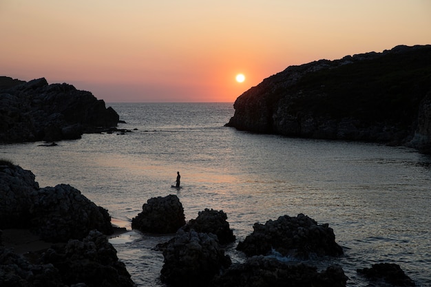 Foto gratuita hombre de vista frontal surfeando al atardecer