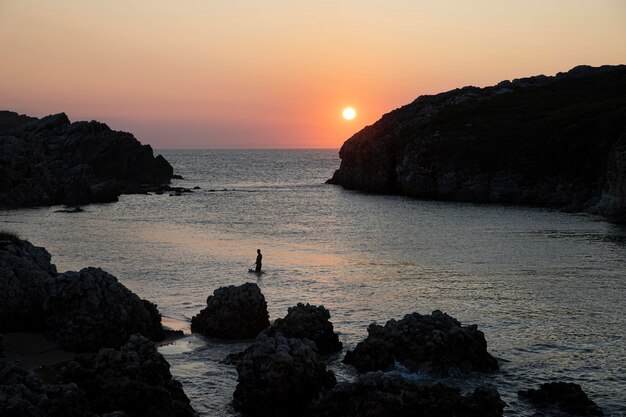 Hombre de vista frontal surfeando al atardecer