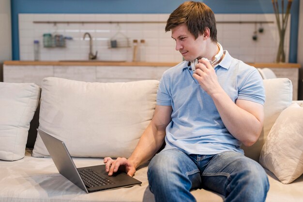 Hombre de vista frontal trabajando en la computadora portátil desde casa