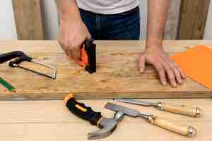 Foto gratuita hombre de vista frontal usando una herramienta de pistola en madera