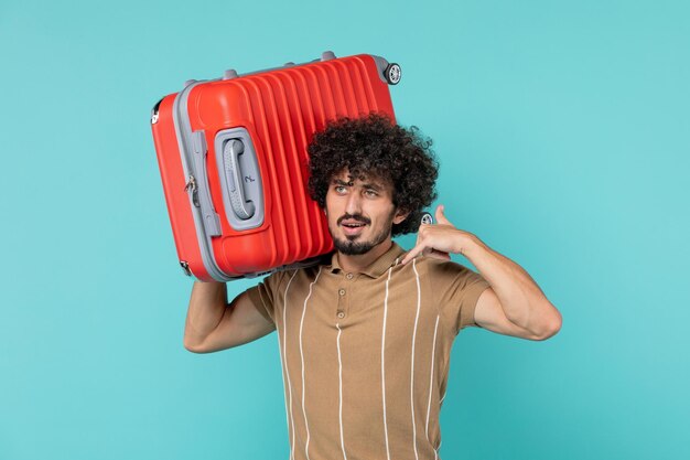 Hombre de vista frontal en vacaciones sosteniendo su gran bolsa en azul claro