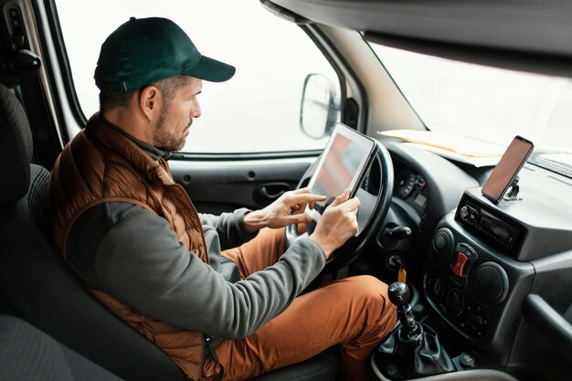 Hombre de vista lateral en coche entregando paquete