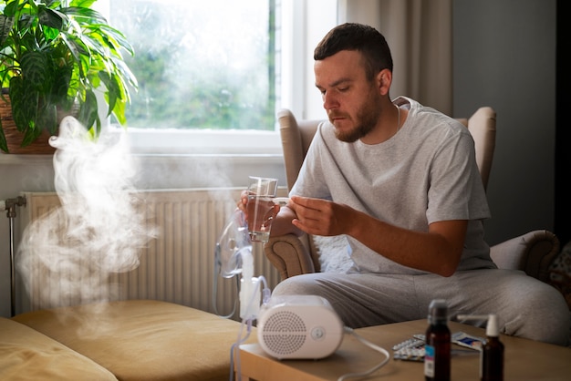 Foto gratuita hombre de vista lateral usando un nebulizador