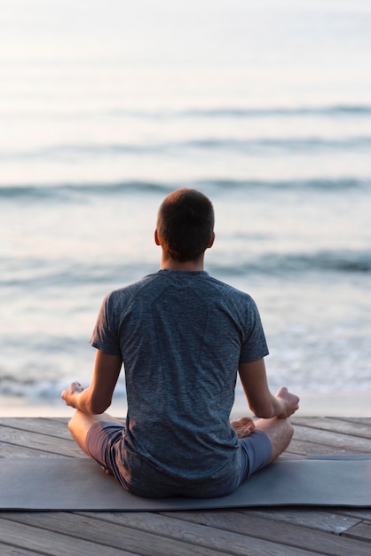 Hombre de vista posterior en loto meditando