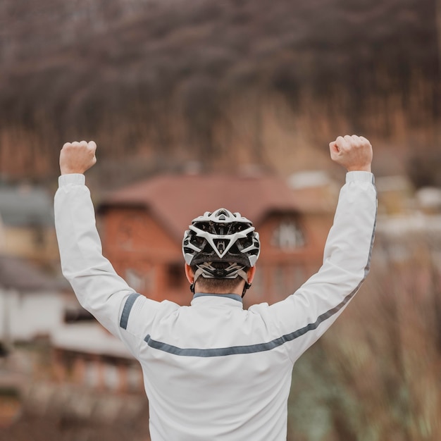 Hombre de vista posterior con sombrero de seguridad para bicicletas en la cabeza