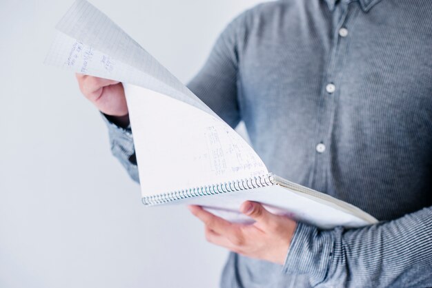 Hombre volteando páginas en el cuaderno