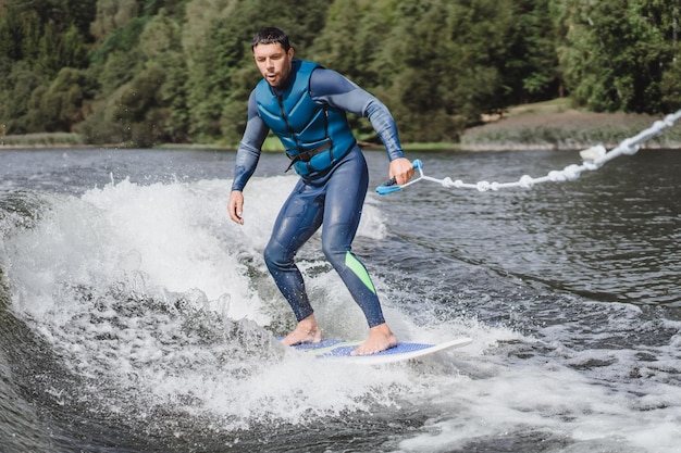 Foto gratuita hombre en wakesurfing. ola desde el barco.