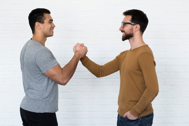 Foto gratuita hombres adultos positivos tomados de la mano