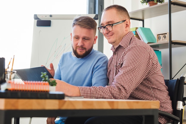 Hombres adultos positivos trabajando juntos en proyecto