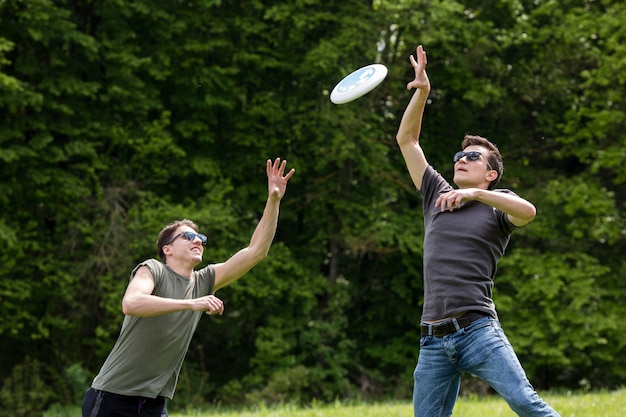 Hombres adultos saltando alto para atrapar el frisbee